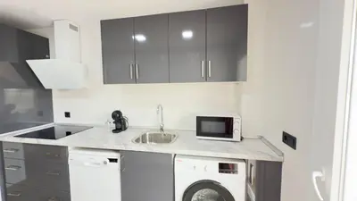 a kitchen with a sink and a washing machine at Punto Mágico, apartamento junto al mar in Poblado de Sancti Petri