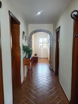 a hallway with a tile floor and an archway at Villa Sofía in Chiclana de la Frontera