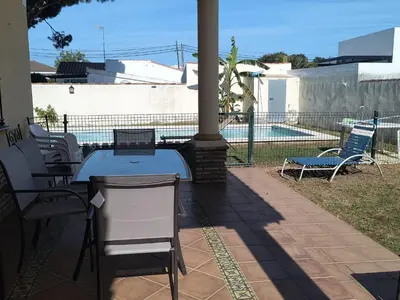 a table and chairs on a patio next to a pool at Villa Sofía in Chiclana de la Frontera