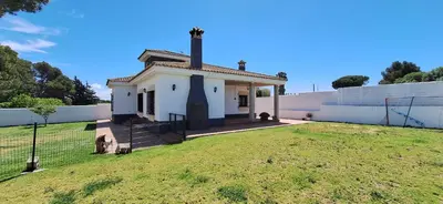 an old house with a fence and a grass field at Villa Dana in Chiclana de la Frontera