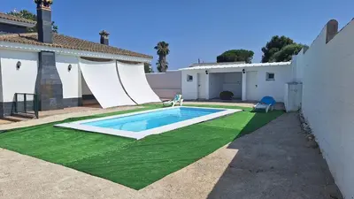 a swimming pool in the backyard of a house at Villa Dana in Chiclana de la Frontera