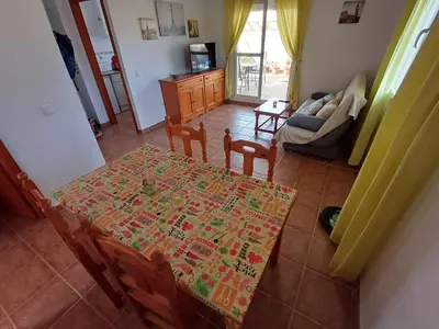 a living room with a table and chairs and a couch at Ático 