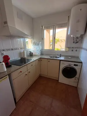a kitchen with a sink and a washing machine at Ático 