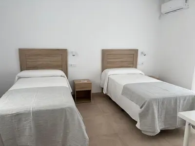 two beds sitting next to each other in a room at Alojamientos VICTORIA MAR-CHIPIONA- in Chipiona