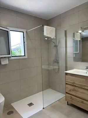 a bathroom with a shower with a glass door at Alojamientos VICTORIA MAR-CHIPIONA- in Chipiona