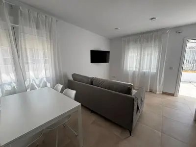 a living room with a couch and a table at Alojamientos VICTORIA MAR-CHIPIONA- in Chipiona