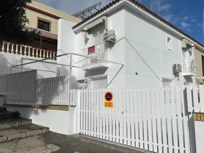 a white house with a white picket fence at Alojamientos VICTORIA MAR-CHIPIONA- in Chipiona