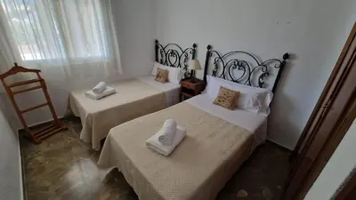 a bedroom with two beds with towels on them at La Barrosa - Chalet La Morenita in Chiclana de la Frontera