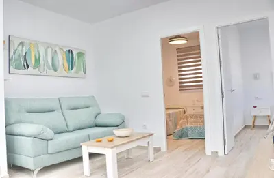 a living room with a blue couch and a table at El Rincon de Lidia in Conil de la Frontera