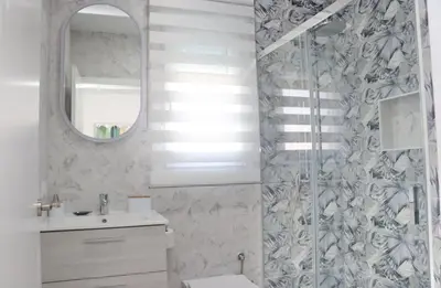 a bathroom with a shower and a toilet and a mirror at El Rincon de Lidia in Conil de la Frontera