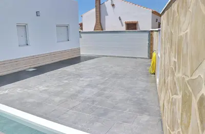 an empty patio with a fence and a white garage at El Rincon de Lidia in Conil de la Frontera