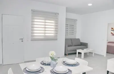 a white living room with a table and a couch at El Rincon de Samuel in Conil de la Frontera