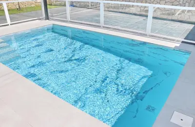 a swimming pool with blue water in a house at El Rincon de Samuel in Conil de la Frontera