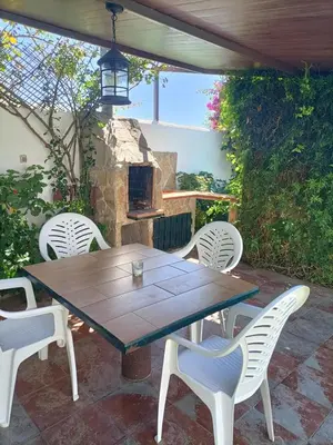 a table and chairs on a patio with a fireplace at Viangel 1 in Conil de la Frontera