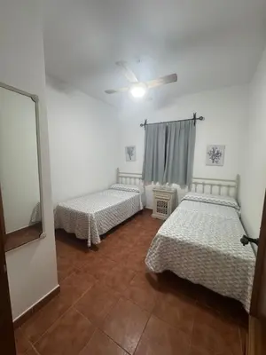 a room with two beds and a ceiling fan at Viangel 1 in Conil de la Frontera