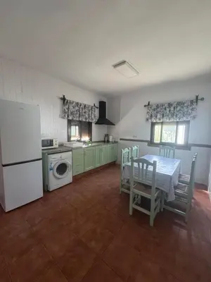 a kitchen with a table and a white refrigerator at Viangel 1 in Conil de la Frontera
