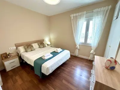 a bedroom with a bed and a large window at GATU Malvasía- Valdelagrana in El Puerto de Santa María