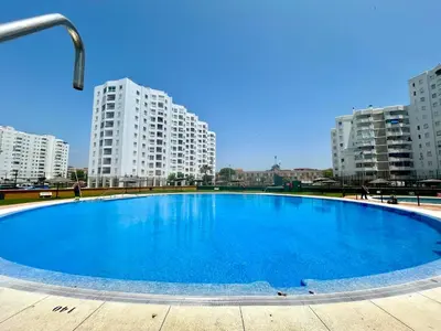 a large blue pool in front of tall buildings at GATU Malvasía- Valdelagrana in El Puerto de Santa María