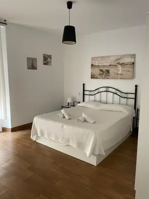 a bedroom with a bed with two towels on it at Luz de La Caleta in Cádiz