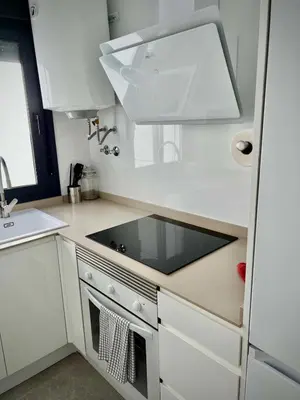 a white kitchen with a sink and a stove top oven at Ático Juan Grande 17 by Sanlúcar Housing in Sanlúcar de Barrameda