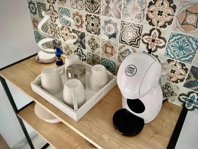 a table with a vase and cups on it at Ático Juan Grande 17 by Sanlúcar Housing in Sanlúcar de Barrameda
