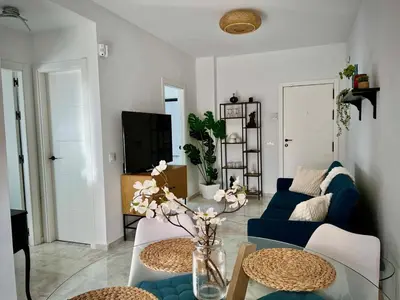 a living room with a blue couch and a table at Ático Juan Grande 17 by Sanlúcar Housing in Sanlúcar de Barrameda