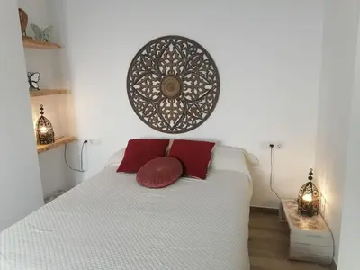 a bedroom with a white bed with two red pillows at Apartamento en San Fernando in San Fernando