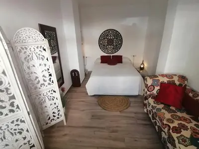 a bedroom with a white bed and a couch at Apartamento en San Fernando in San Fernando