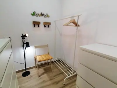 a white room with a chair and a lamp at Apartamento en San Fernando in San Fernando