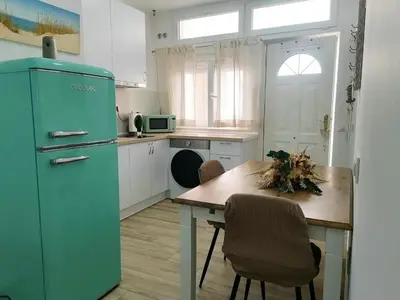 a kitchen with a table and a blue refrigerator at Apartamento en San Fernando in San Fernando