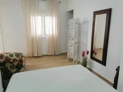 a bedroom with a bed and a mirror and a chair at Apartamento en San Fernando in San Fernando
