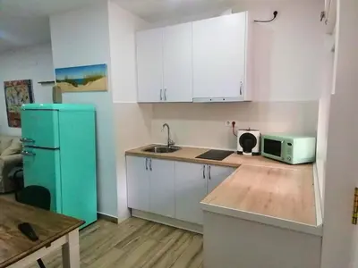 a kitchen with white cabinets and a blue refrigerator at Apartamento en San Fernando in San Fernando