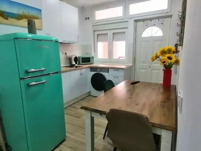 a kitchen with a green refrigerator and a wooden table at Apartamento en San Fernando in San Fernando