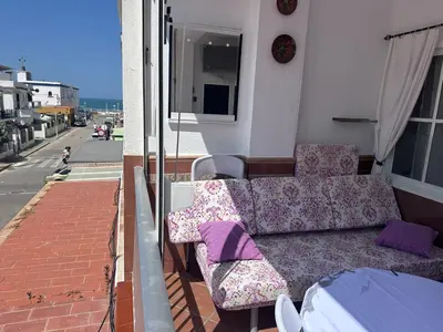 a couch and chairs sitting on a balcony at Chipiona playa in Chipiona