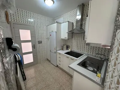a small kitchen with white cabinets and a sink at Chipiona playa in Chipiona
