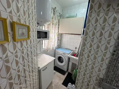 a small kitchen with a washing machine and a sink at Chipiona playa in Chipiona