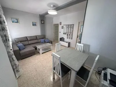 a living room with a table and a couch at Chipiona playa in Chipiona