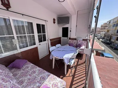 a balcony with two beds and a table on a balcony at Chipiona playa in Chipiona