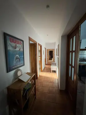 a hallway with a table and a couch in a room at Casa Tropical in Chiclana de la Frontera
