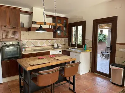 a kitchen with a wooden counter top and a table at Casa Tropical in Chiclana de la Frontera
