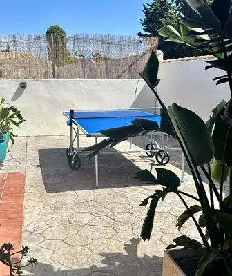 a blue wheelbarrow sitting on a patio at Casa Tropical in Chiclana de la Frontera