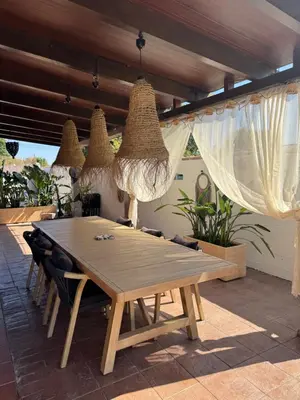 a wooden table and chairs on a patio at Casa Tropical in Chiclana de la Frontera