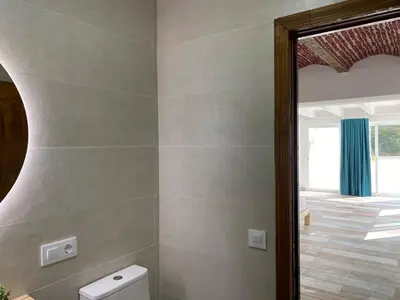a bathroom with a toilet and a mirror at Chalet Albariza in Sanlúcar de Barrameda