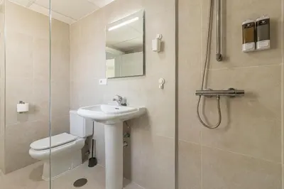 a bathroom with a toilet and a sink and a shower at Allo Apartments Ático Jaramago Parking Centro 1 Hab in Jerez de la Frontera