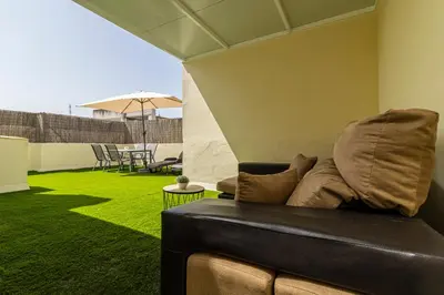 a couch sitting in a living room with a green lawn at Allo Apartments Ático Jaramago Parking Centro 1 Hab in Jerez de la Frontera