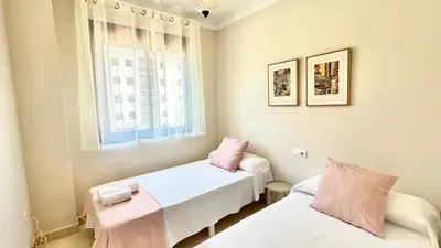 a small room with two beds and a window at SIBS ELPUERTO - SANCIRO Ideal Familias Piscina Parking in El Puerto de Santa María