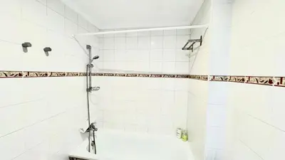 a bathroom with a shower with white tiles at SIBS ELPUERTO - SANCIRO Ideal Familias Piscina Parking in El Puerto de Santa María