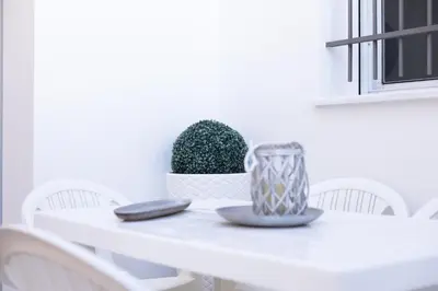 a white dining room table with a plant on it at Royal Rent Sanlúcar Cerro Falón in Sanlúcar de Barrameda