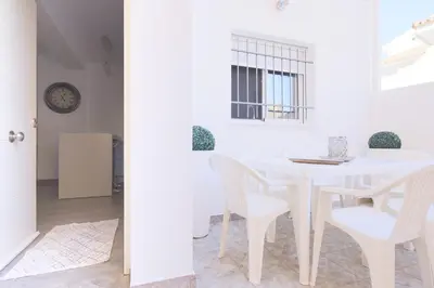 a white dining room with a white table and chairs at Royal Rent Sanlúcar Cerro Falón in Sanlúcar de Barrameda