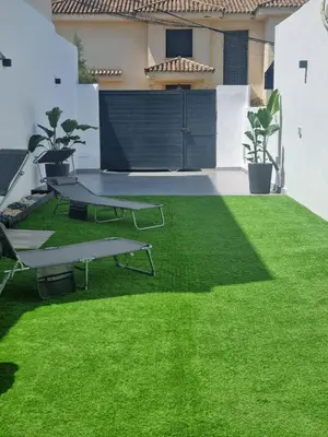 a green lawn with a picnic table in a yard at Apartamentos Sayonara Beach 1 in Sanlúcar de Barrameda